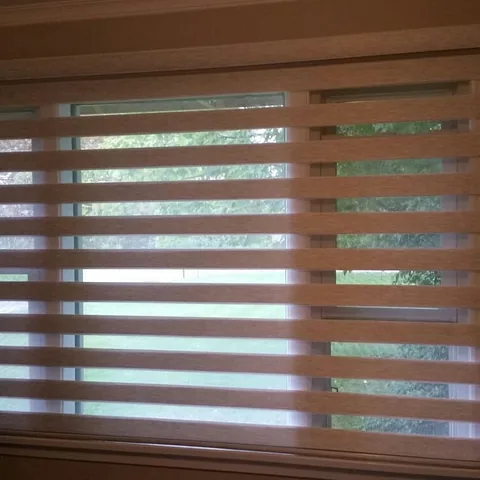 Brown banded shades covering a wide living room window